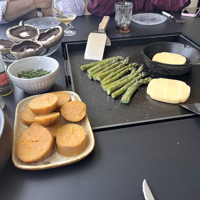 Personas cocinando y compartiendo alrededor de una mesa Volcano, escena 5
